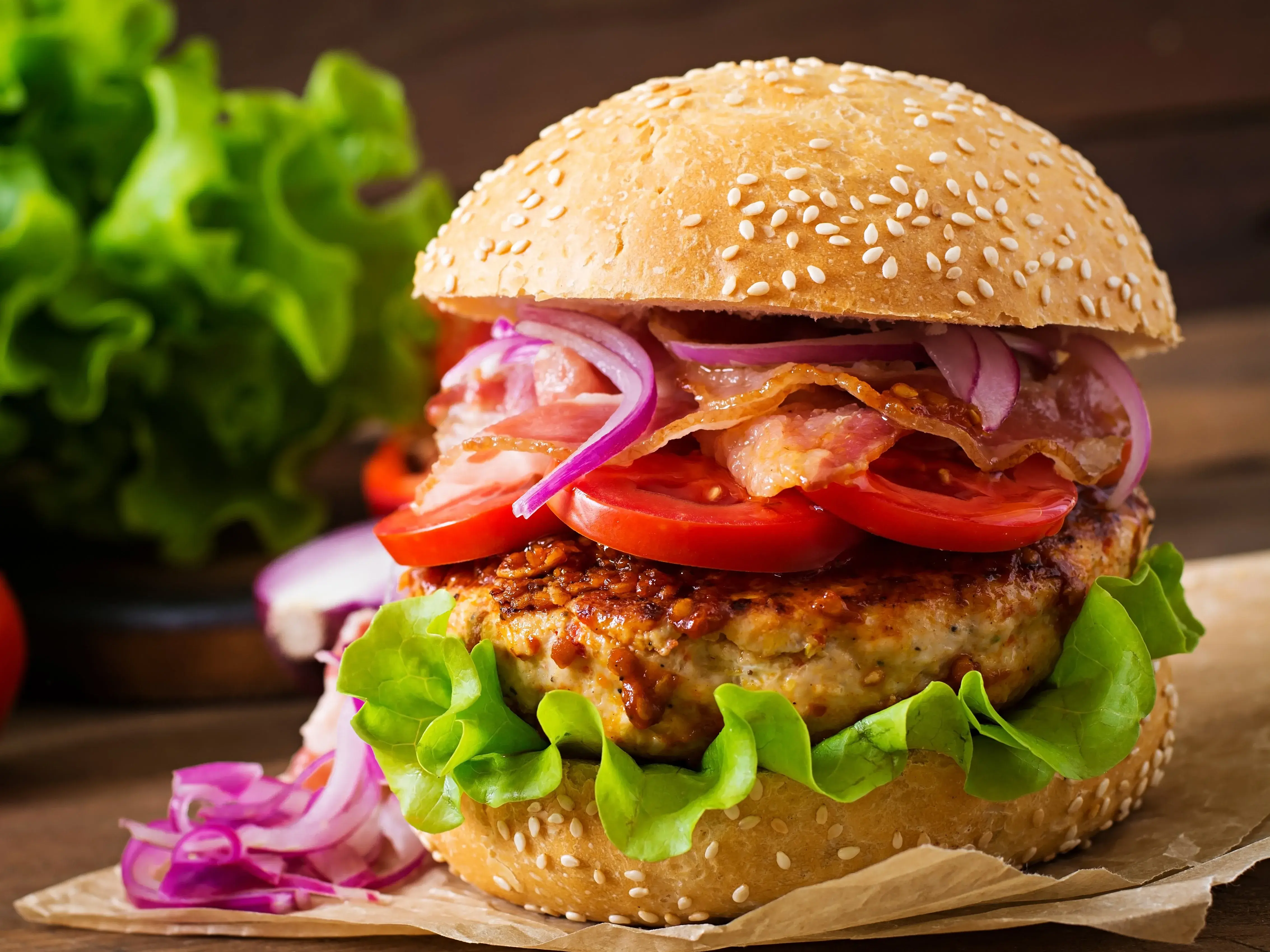 A stacked fake burger with glossy buns and layered fillings.